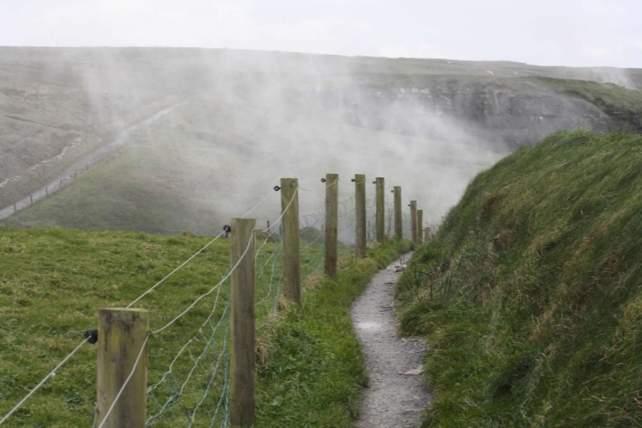 Hiking the Cliffs of Moher Walking Trail in December 3 Ireland-hiking-the-cliffs-of-Moher-walking-trail-fence-mist-from-backwards-waterfalls