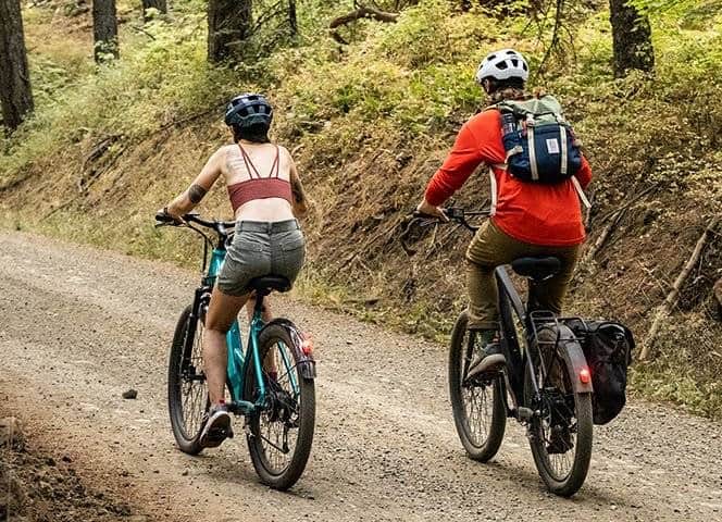 Electric Bikes For Newbies - Shop for the right bike (2023) 9 A couple riding electric bikes through the woods